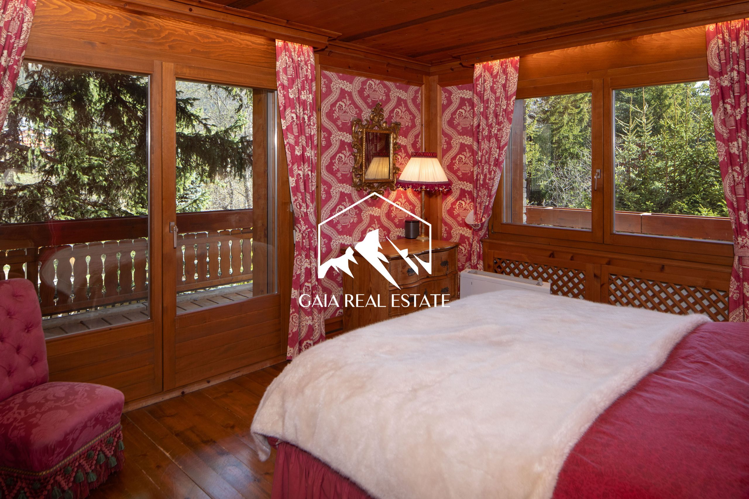 Schlafzimmer mit Holzvertäfelung und Balkonblick