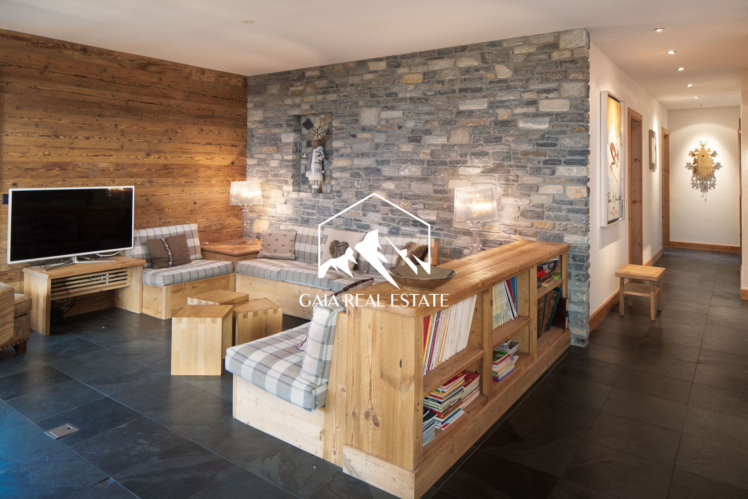 Gemütlicher Wohnbereich mit Natursteinwand und Holzelementen