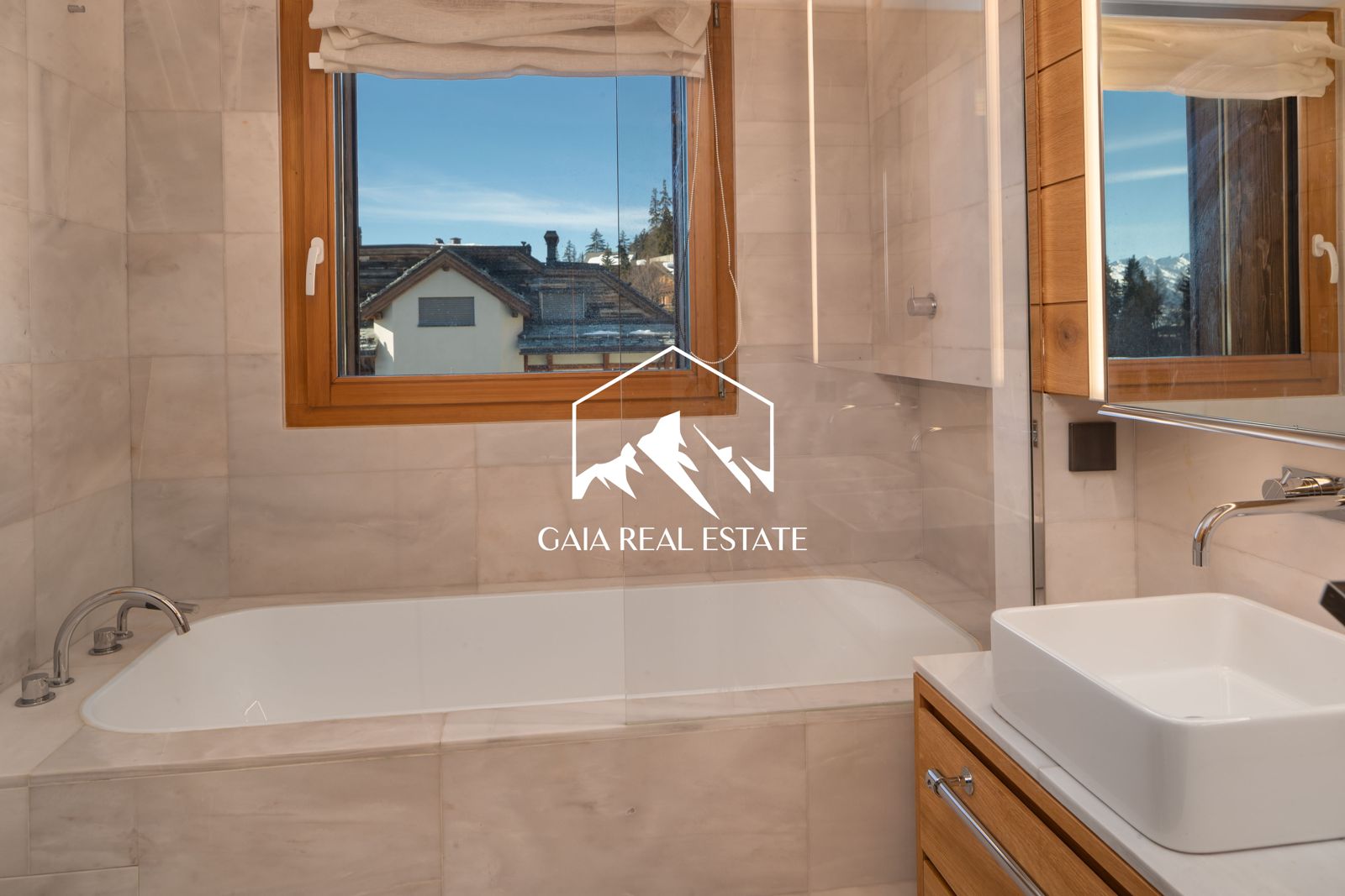 Helles Badezimmer mit Badewanne und Bergblick