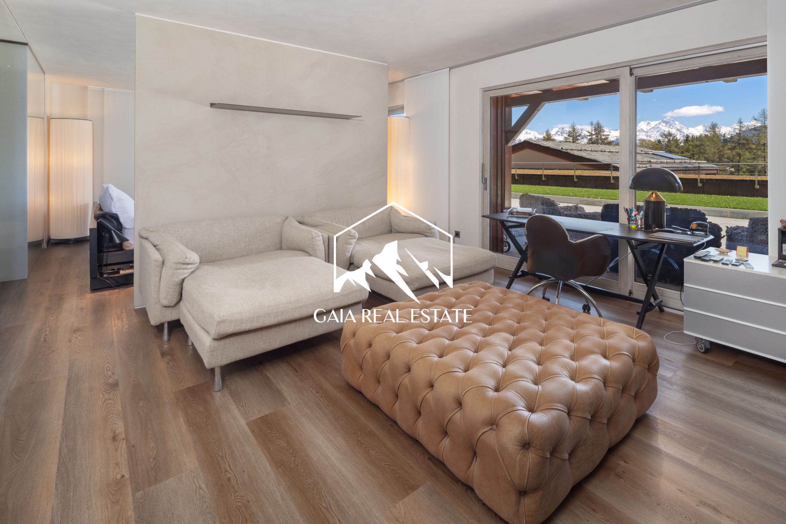 Modernes Wohnzimmer mit Arbeitsplatz und Bergblick