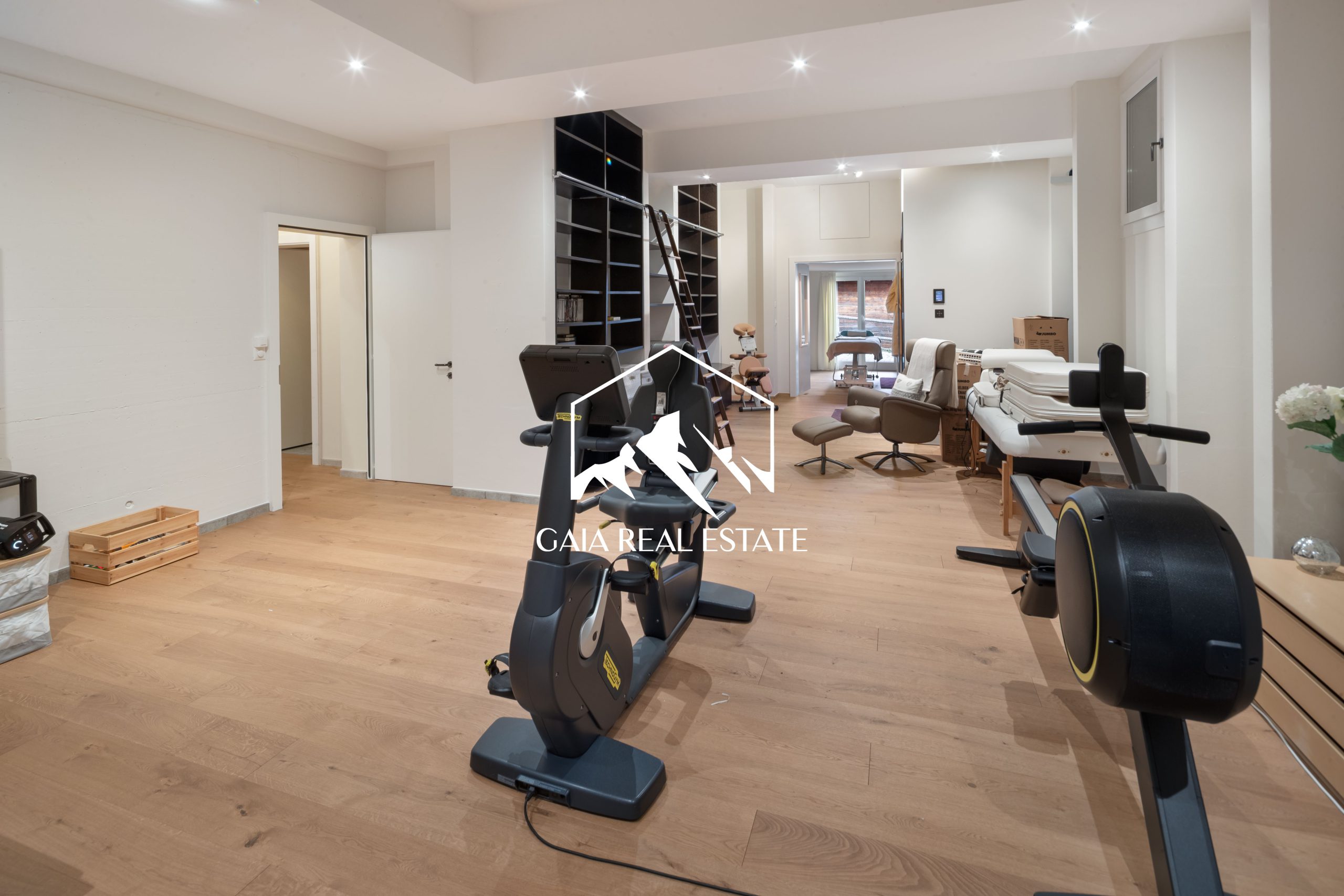 Fitnessraum mit Trainingsgeräten und Regalen
