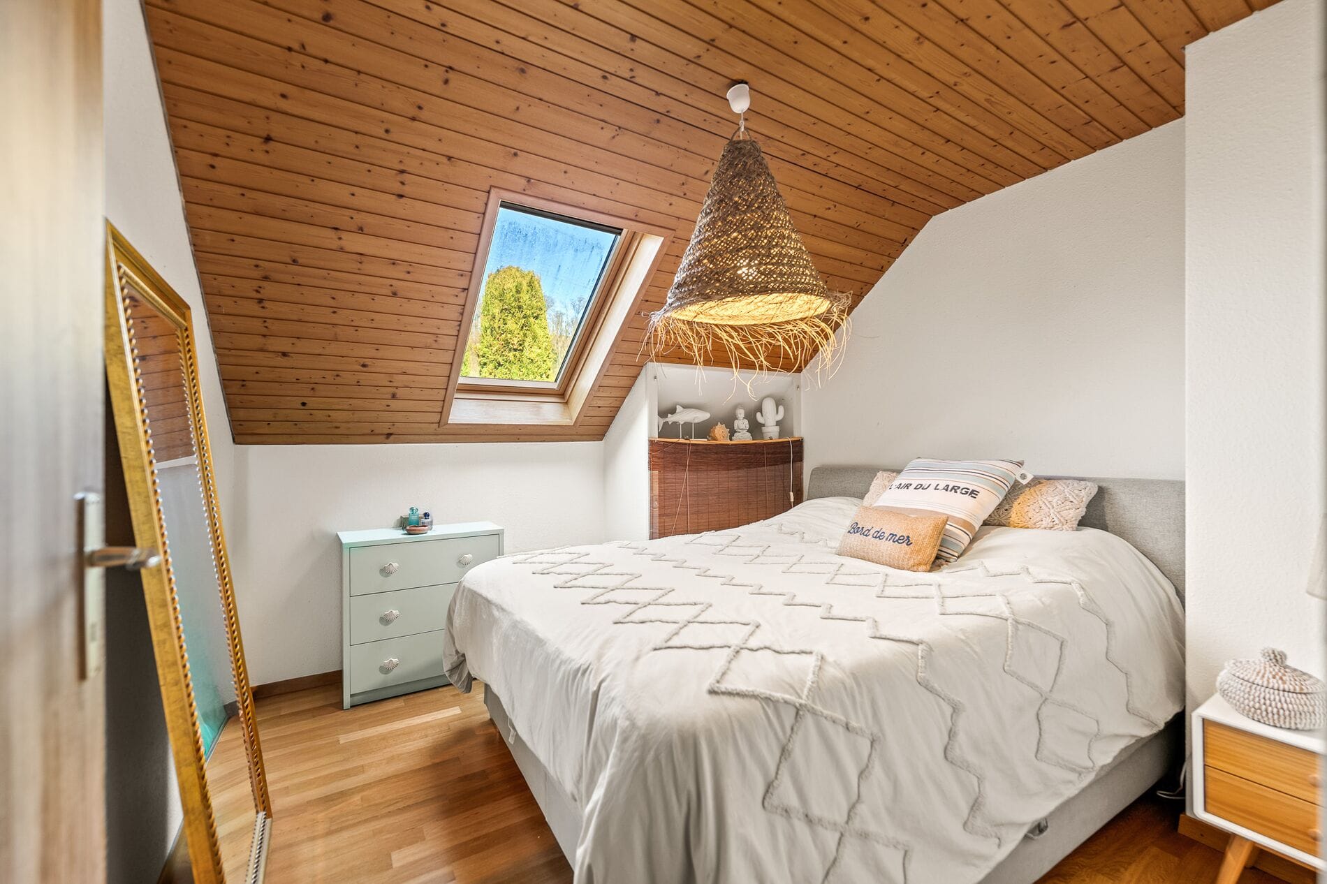 Gemütliches Dachgeschoss-Schlafzimmer mit Holzdecke und Dachfenster