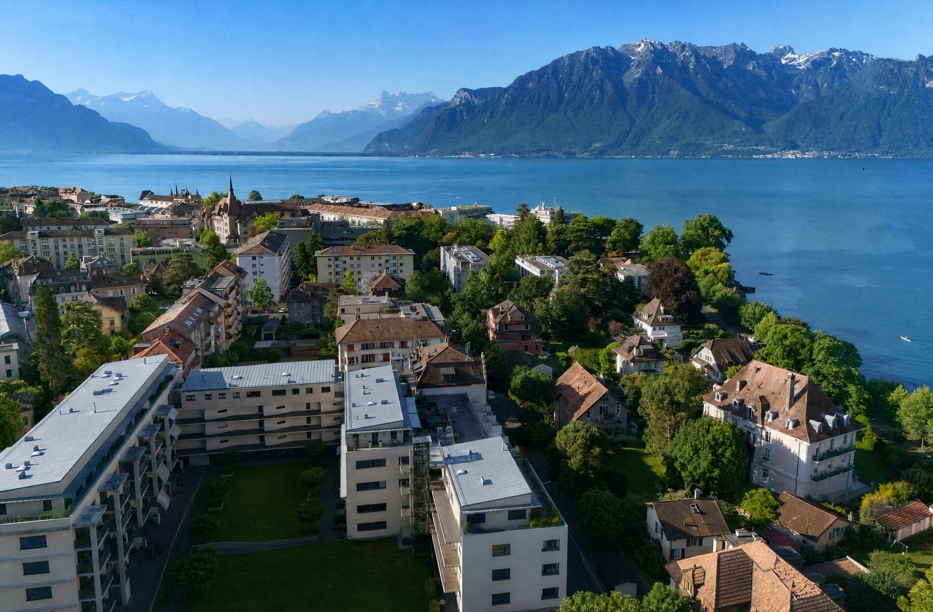 Seeblick über Stadt und Alpen
