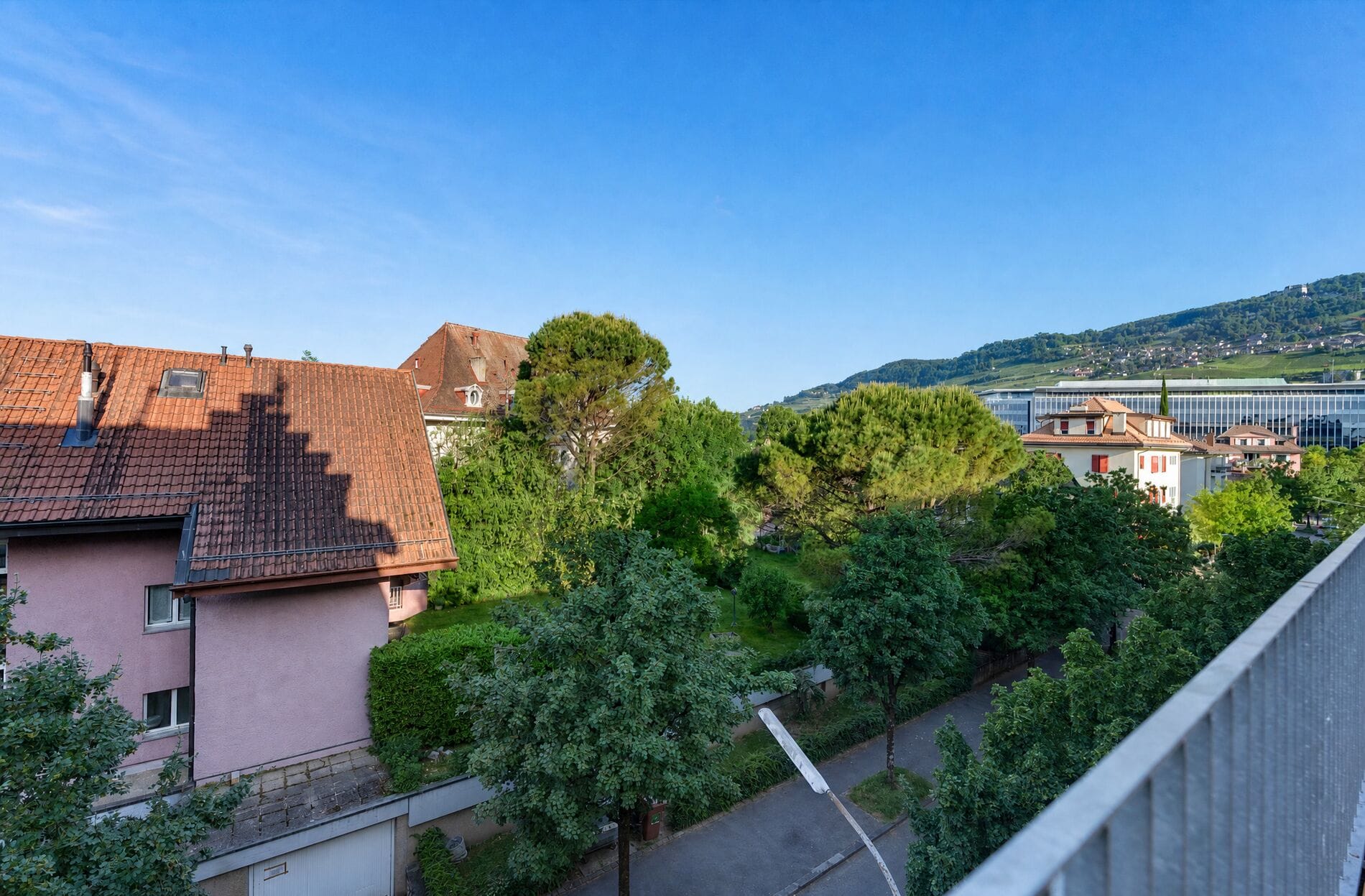 Blick vom Balkon auf Wohnhäuser und Hügellandschaft