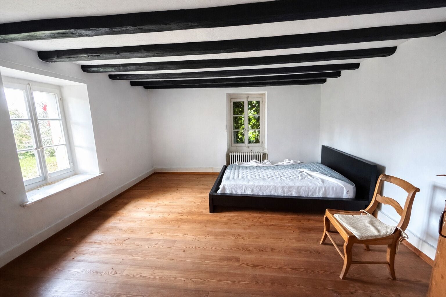 Helles Schlafzimmer mit sichtbaren Holzbalken