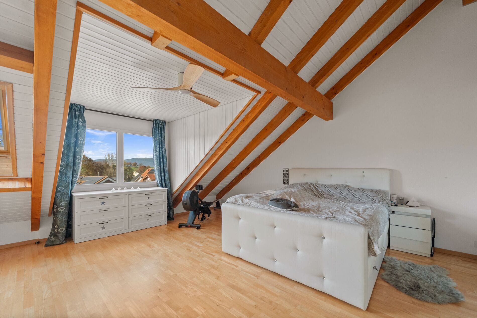 Ausgebautes Dachgeschoss-Schlafzimmer mit sichtbaren Holzbalken