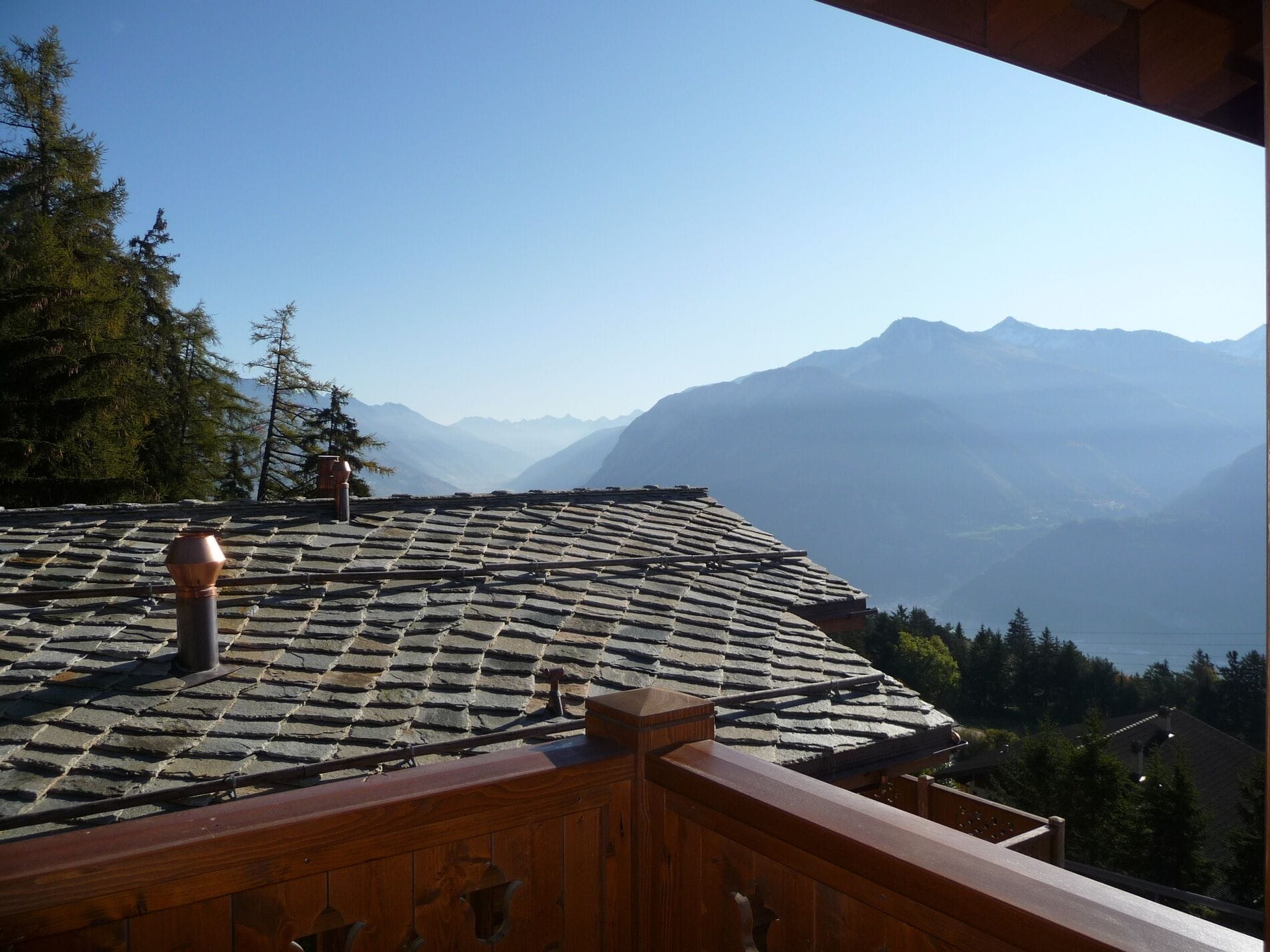 Bergblick von einem Holzbalkon mit Schieferdach
