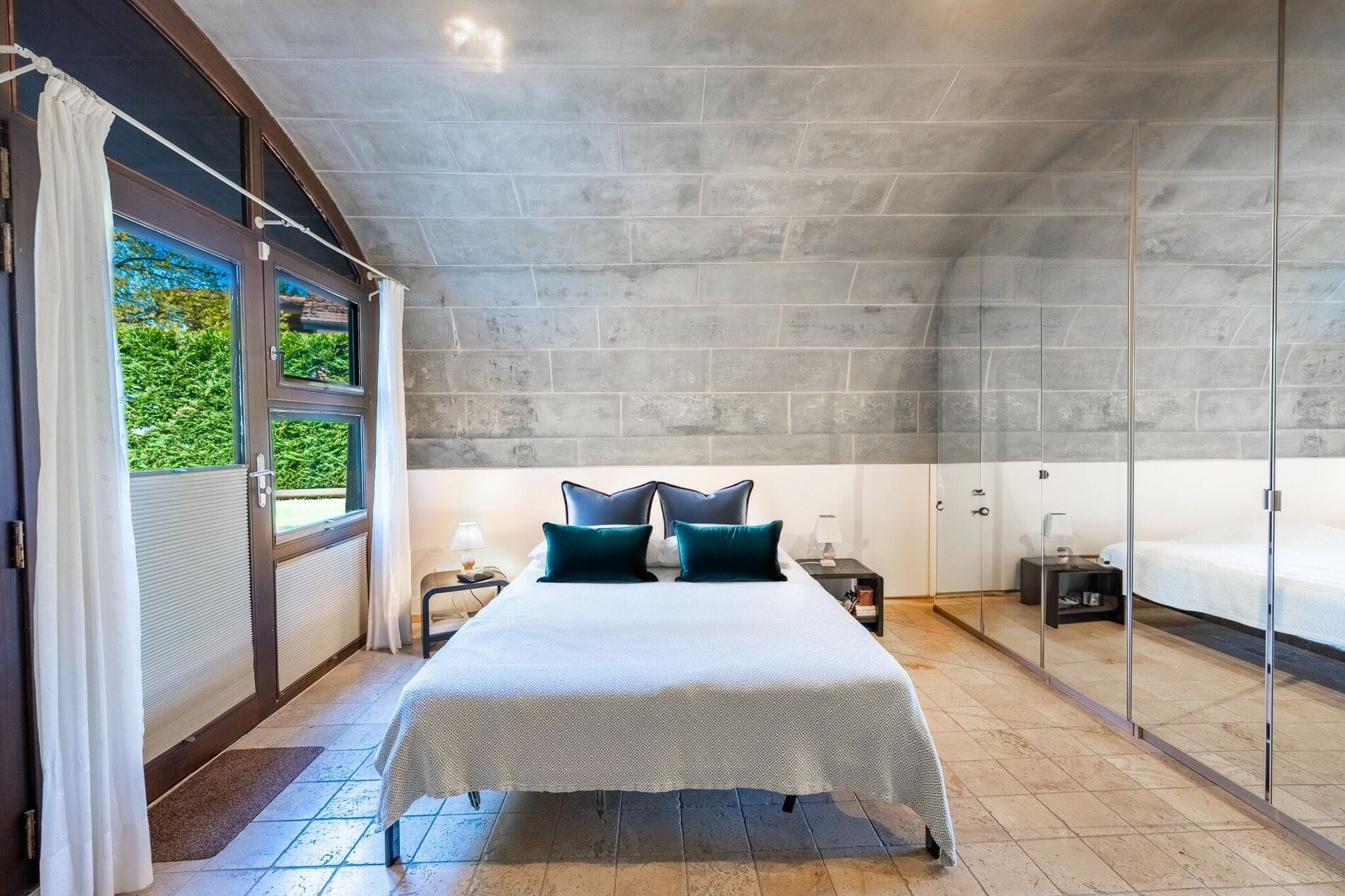 Schlafzimmer mit großen Fenstern und Spiegelkleiderschrank