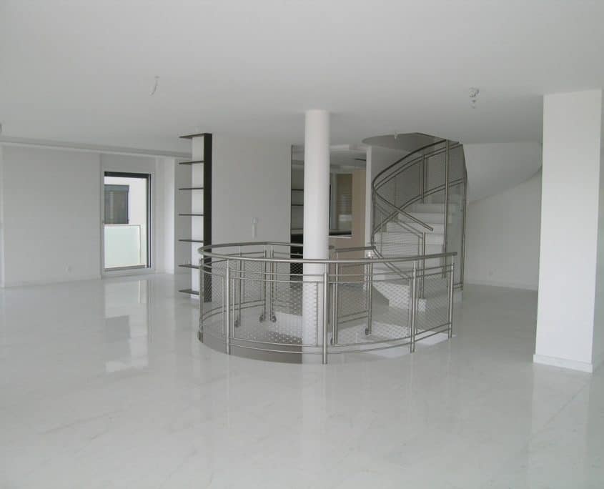 Großer leerer Wohnbereich mit Wendeltreppe