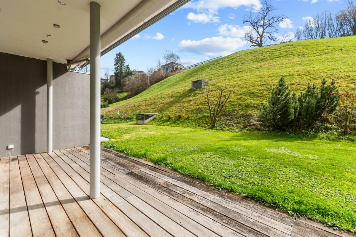 Überdachte Holzterrasse mit Gartenblick