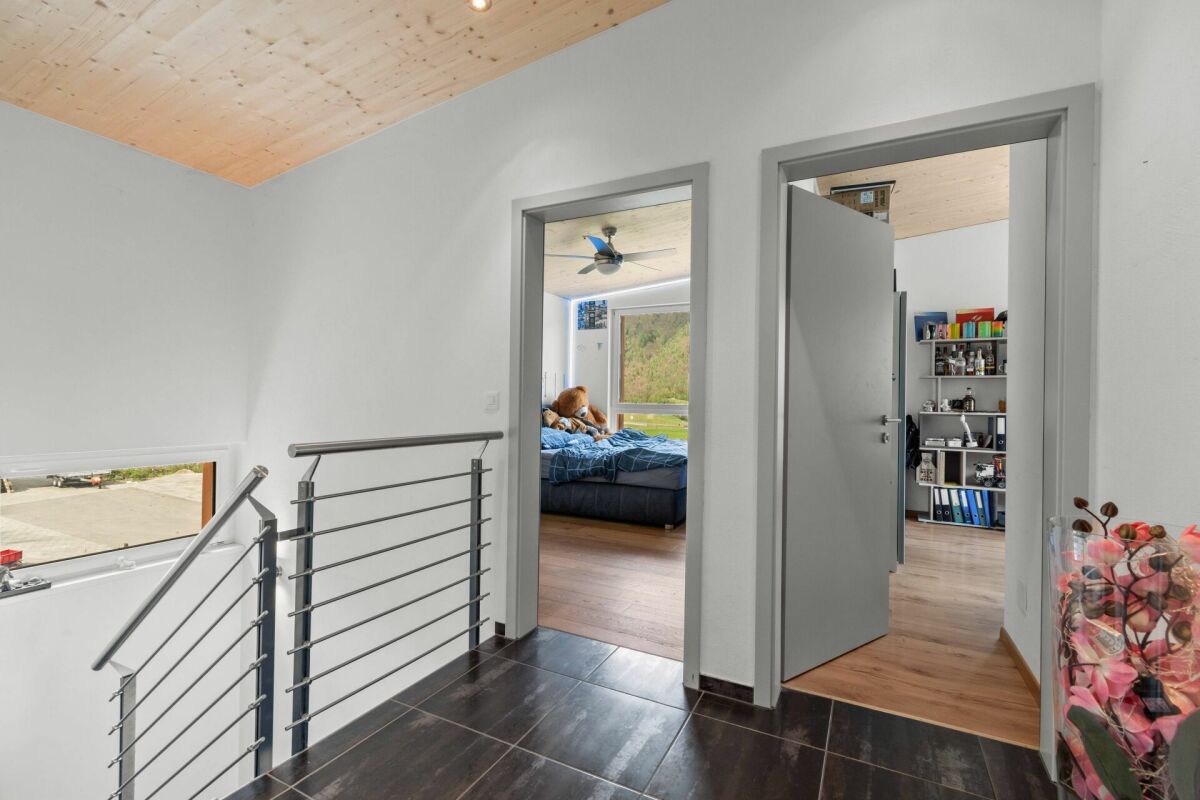 Flur mit Treppenaufgang und Blick in Schlafzimmer und Arbeitsraum