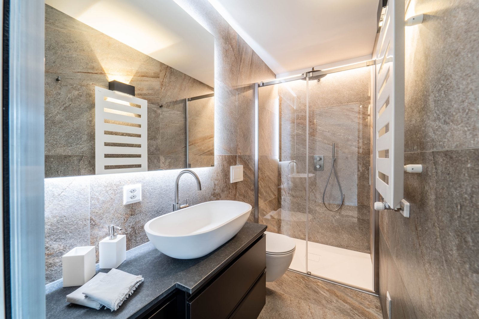 Modernes Badezimmer mit Natursteinoptik und Glasdusche