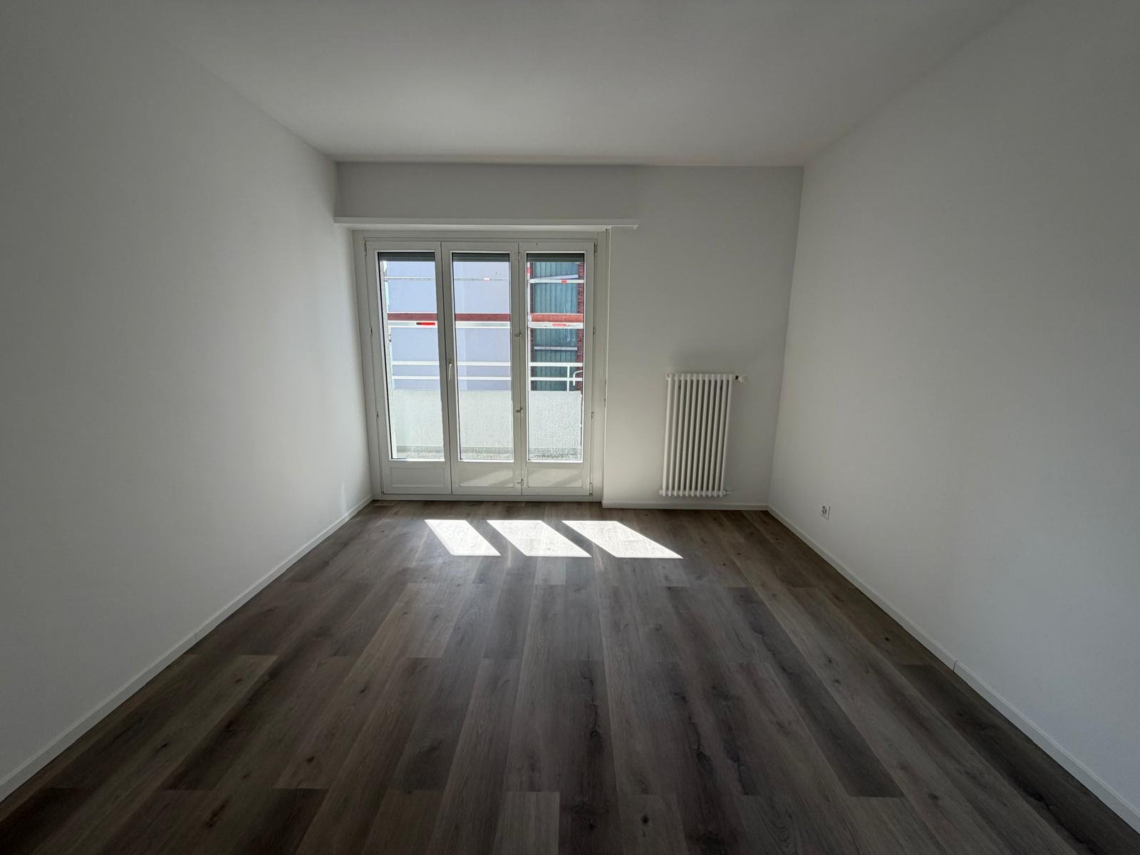 Heller leerer Wohnraum mit Balkonfenster