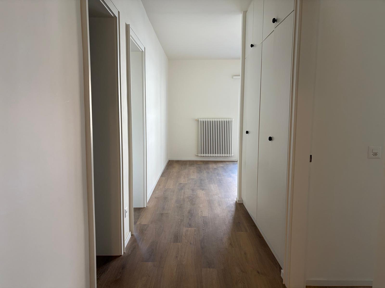 Heller Flur mit Holzboden und Einbauschrank