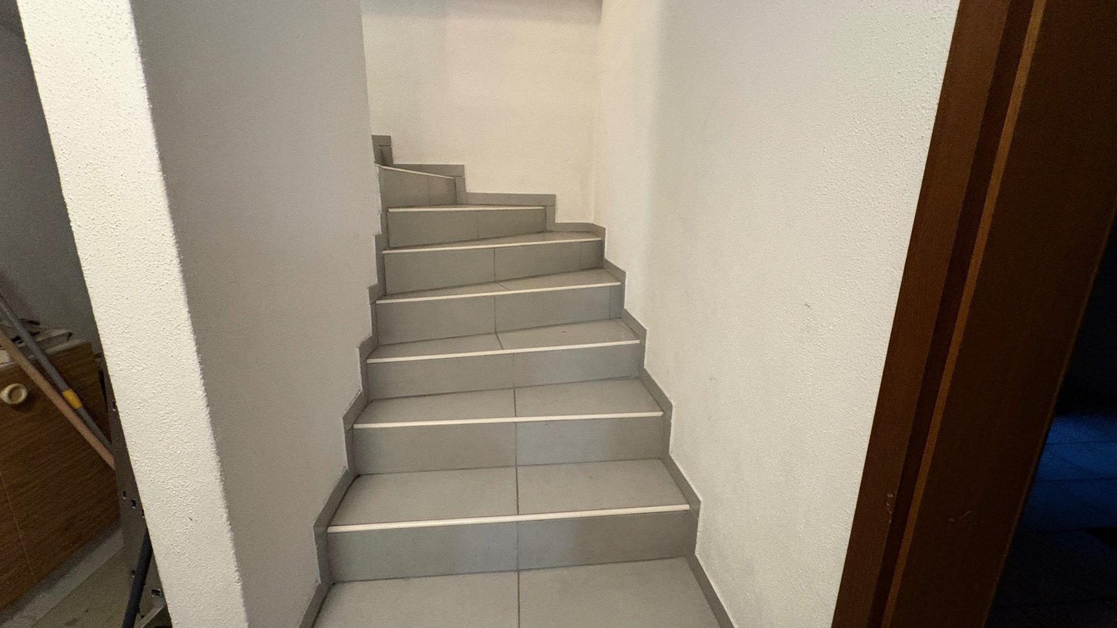 Treppenhaus mit grauen Fliesenstufen