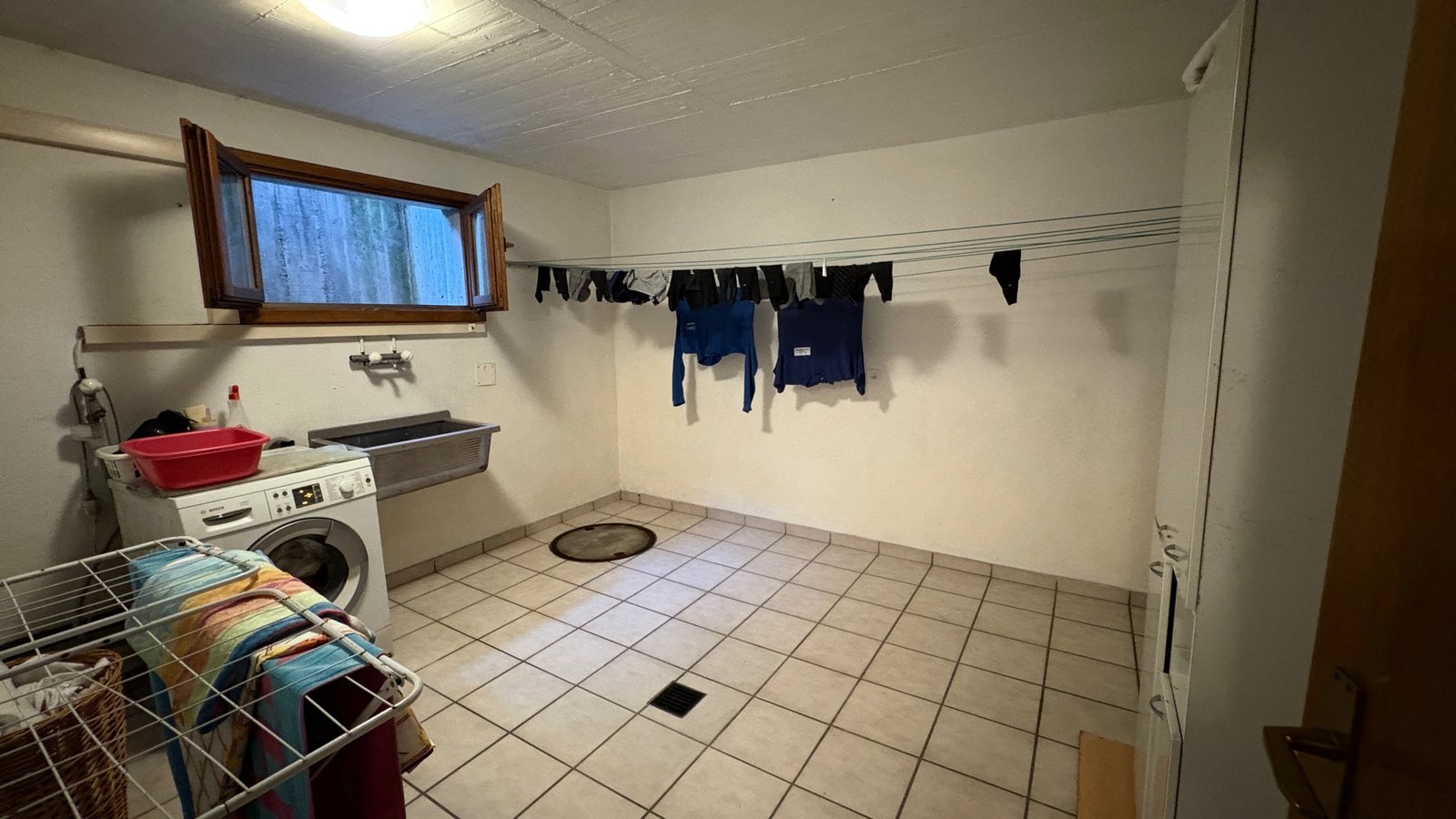 Hauswirtschaftsraum mit Waschmaschine und Wäscheleinen