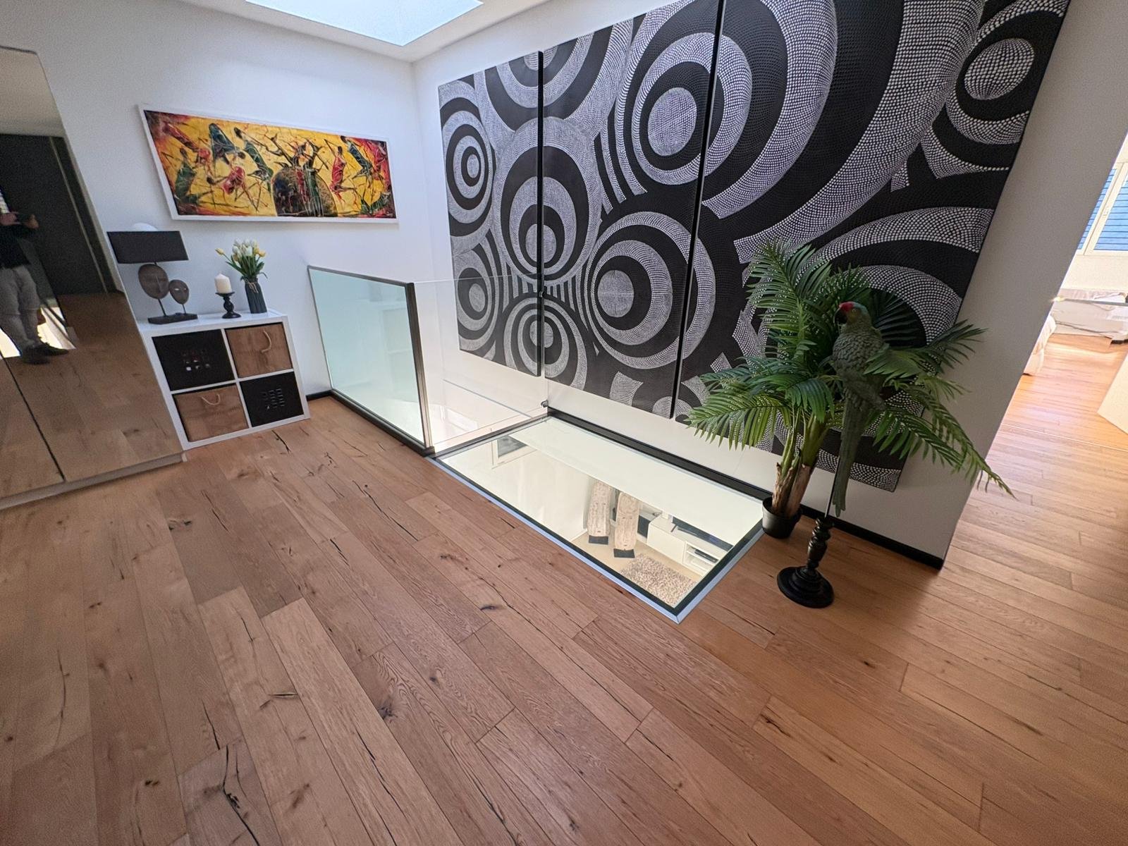 Offene Galerie mit Kunstwand und Holzfußboden