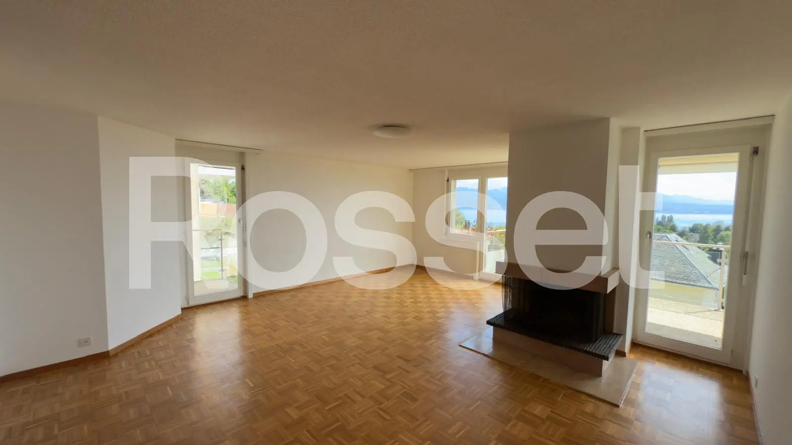 Heller Wohnraum mit Kamin und Seeblick