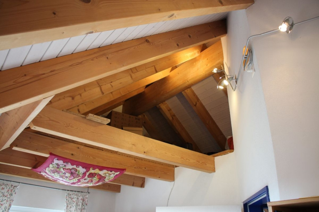 Dachgeschossraum mit sichtbaren Holzbalken