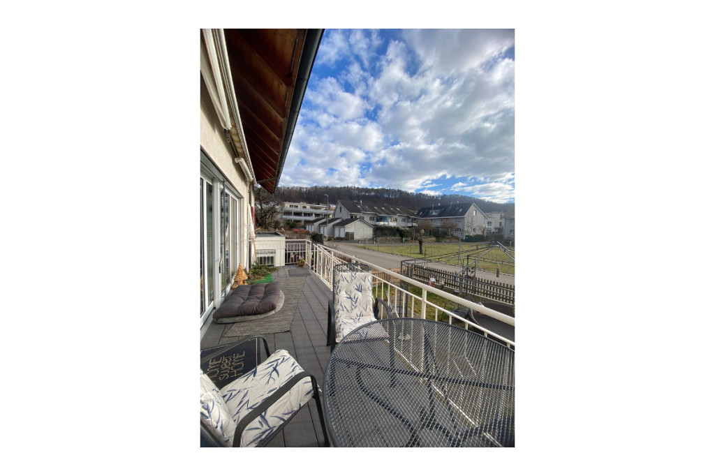 Balkon mit Sitzmöbeln und Ausblick auf Wohnhäuser