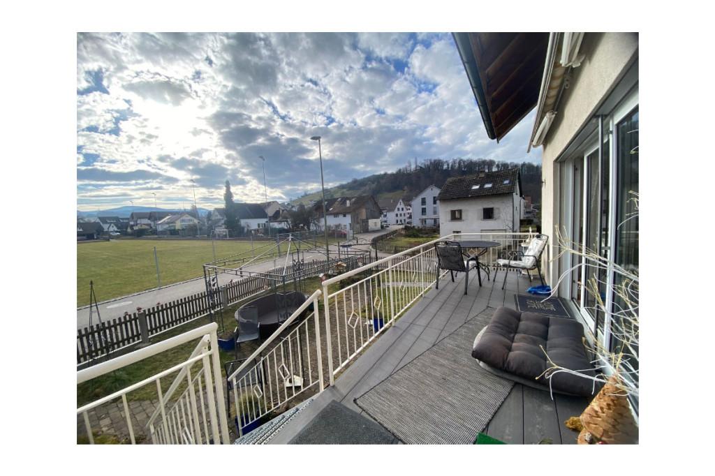 Balkon mit Blick auf Sportplatz und Wohngebiet