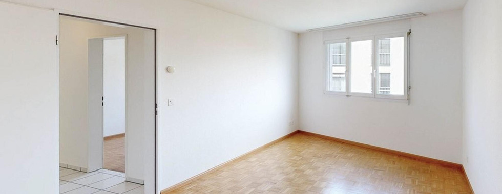 Heller leerer Wohnraum mit Fenster und Türöffnung