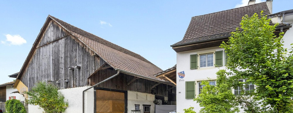 Außenansicht eines ländlichen Wohngebäudes mit Scheune und Haus