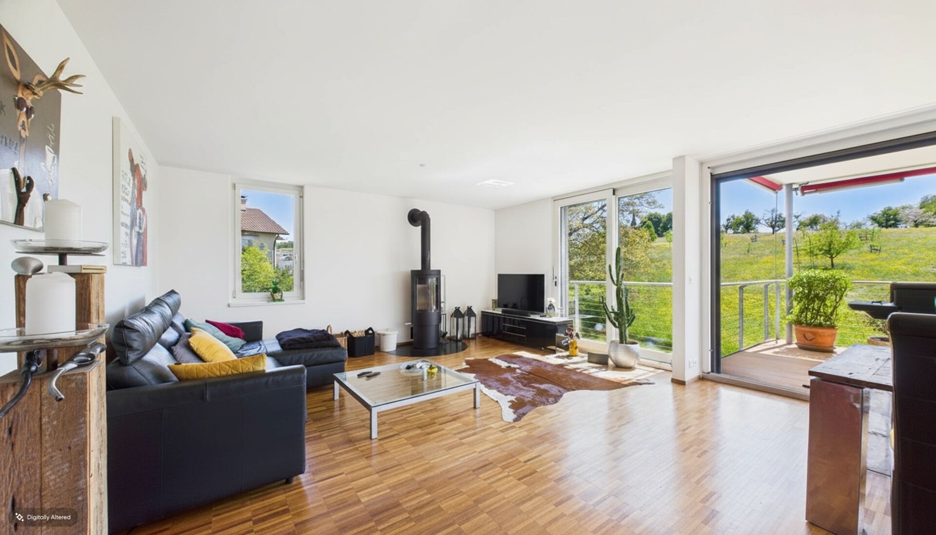 Heller Wohnraum mit Kamin und Blick ins Grüne