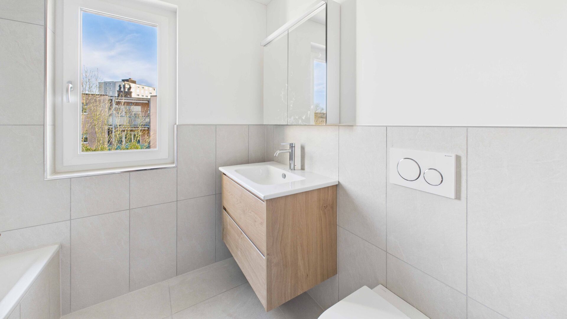 Modernes Badezimmer mit Fenster und Holzwaschtisch