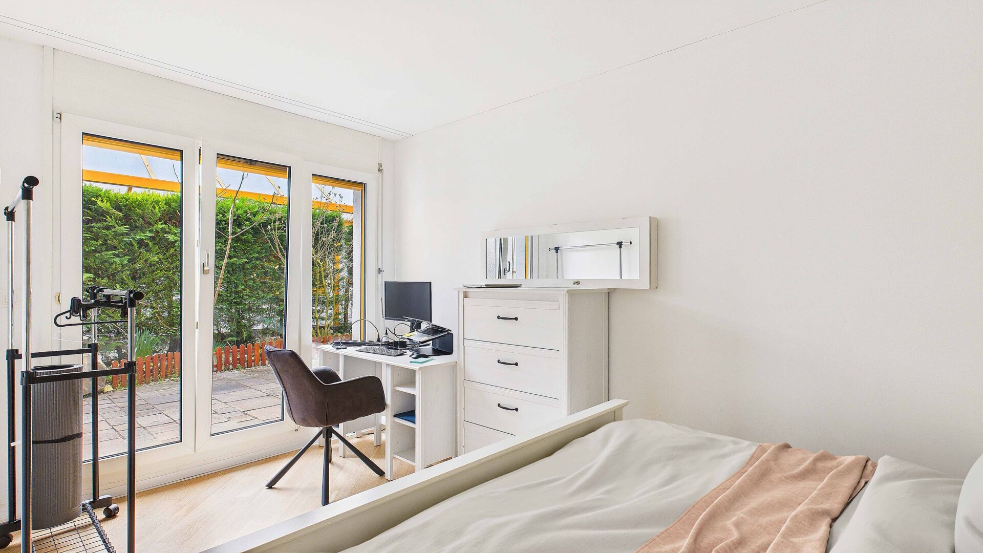 Helles Schlafzimmer mit Arbeitsbereich und Terrassentür