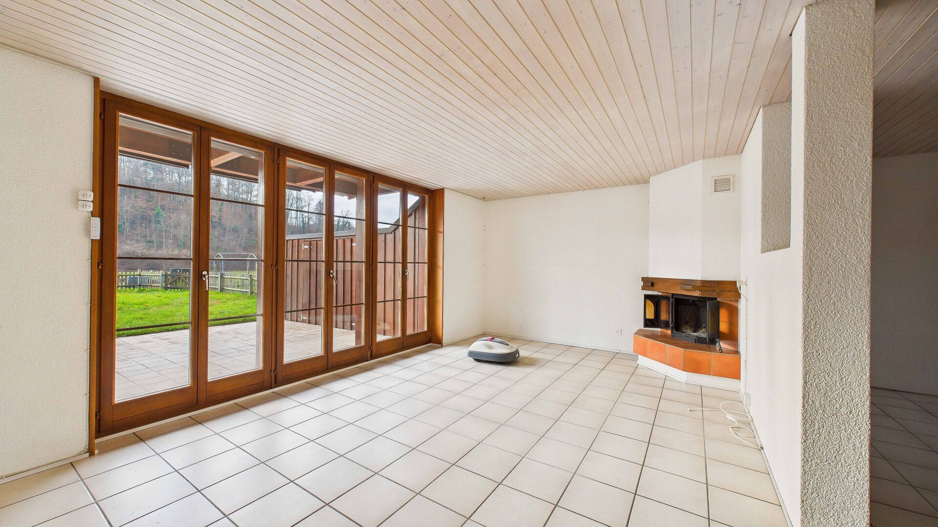 Heller Wohnraum mit Kamin und großer Fensterfront