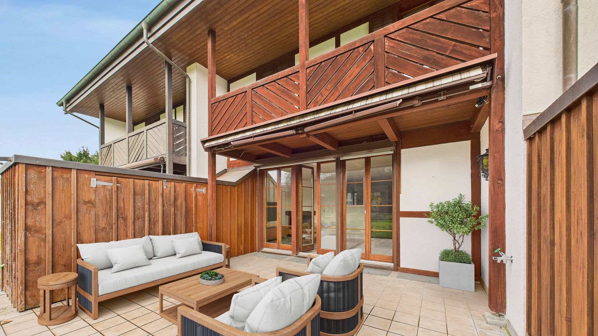 Überdachte Holzterrasse mit Lounge-Möbeln