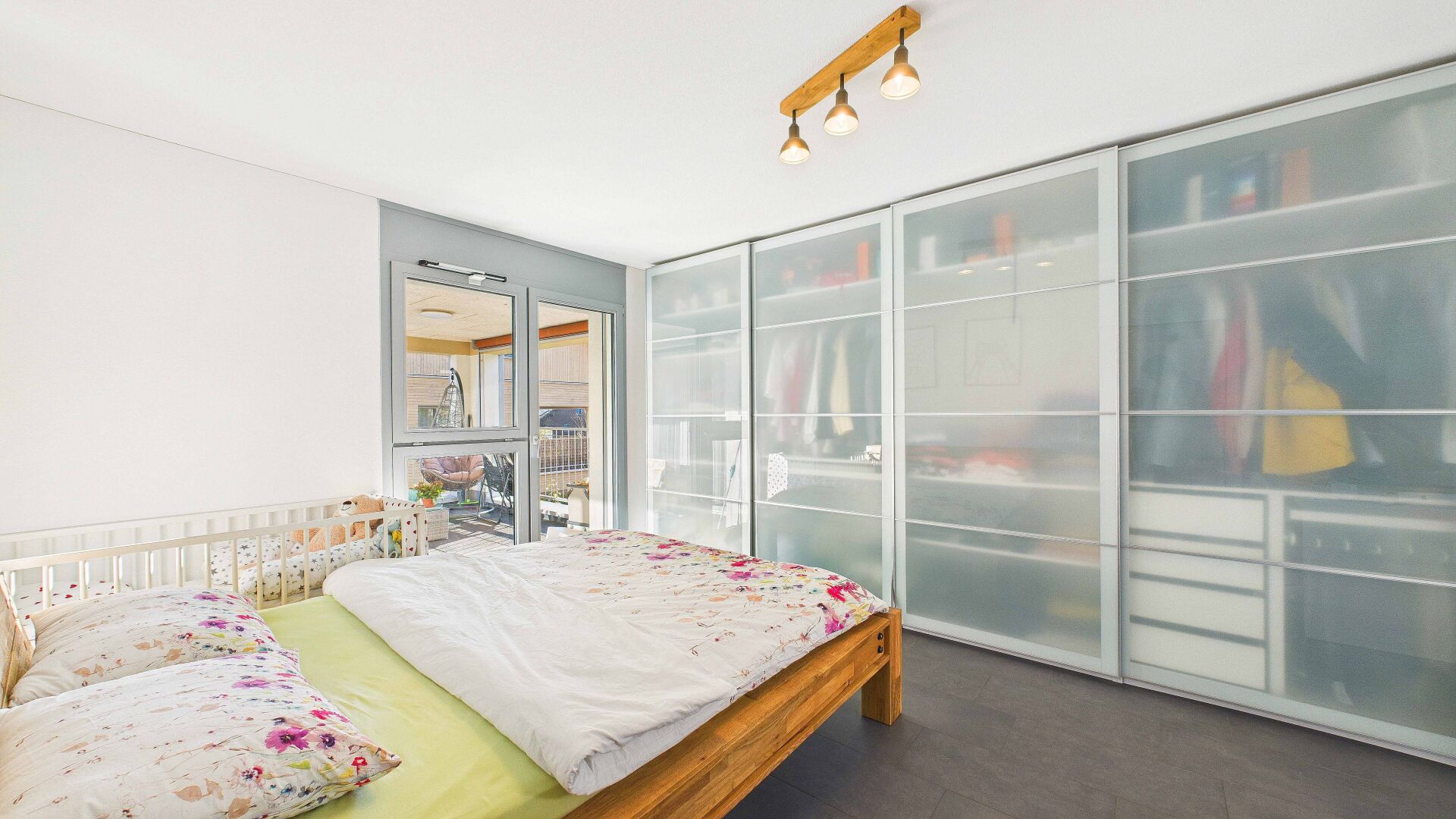 Helles Schlafzimmer mit großem Kleiderschrank und Zugang zum Balkon