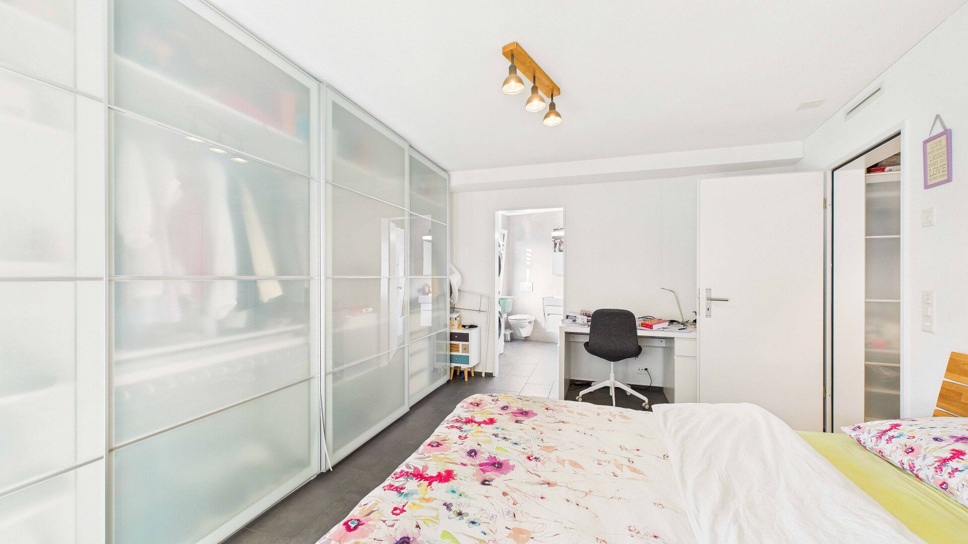 Helles Schlafzimmer mit begehbarem Kleiderschrank und Arbeitsplatz