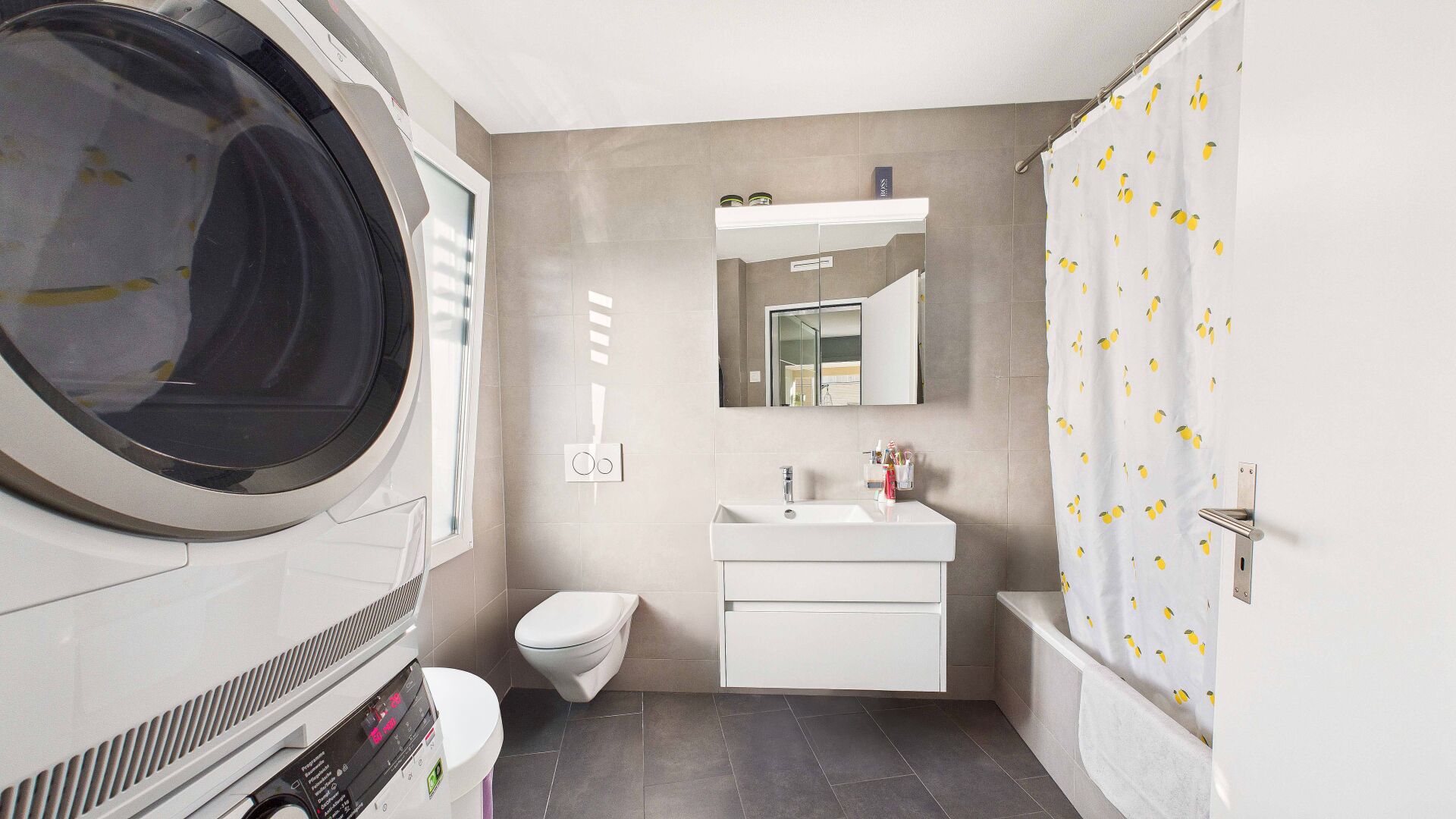 Helles Badezimmer mit Waschmaschine und Badewanne