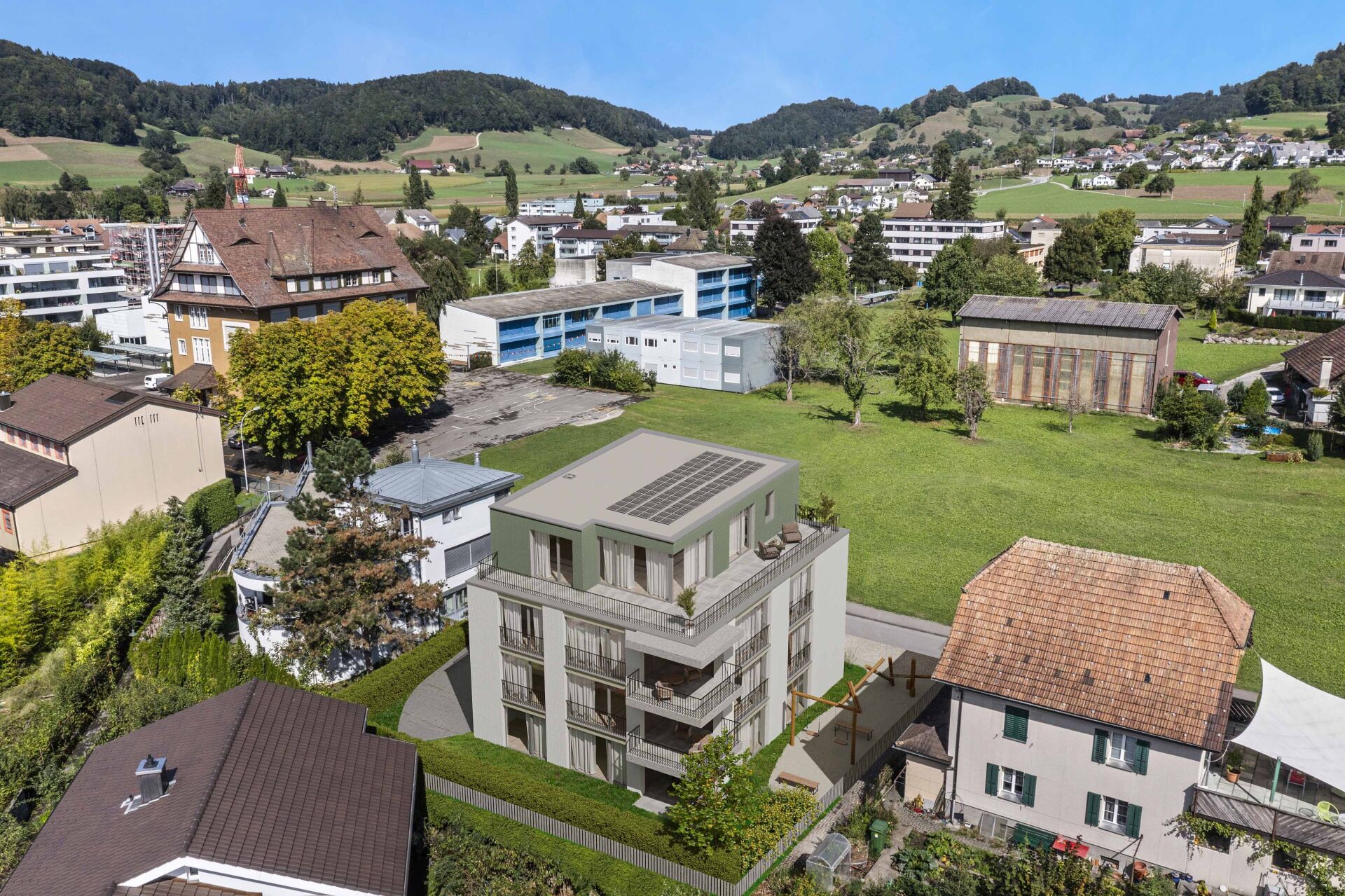 Luftaufnahme eines modernen Wohngebäudes in einer grünen Tal- und Berglandschaft