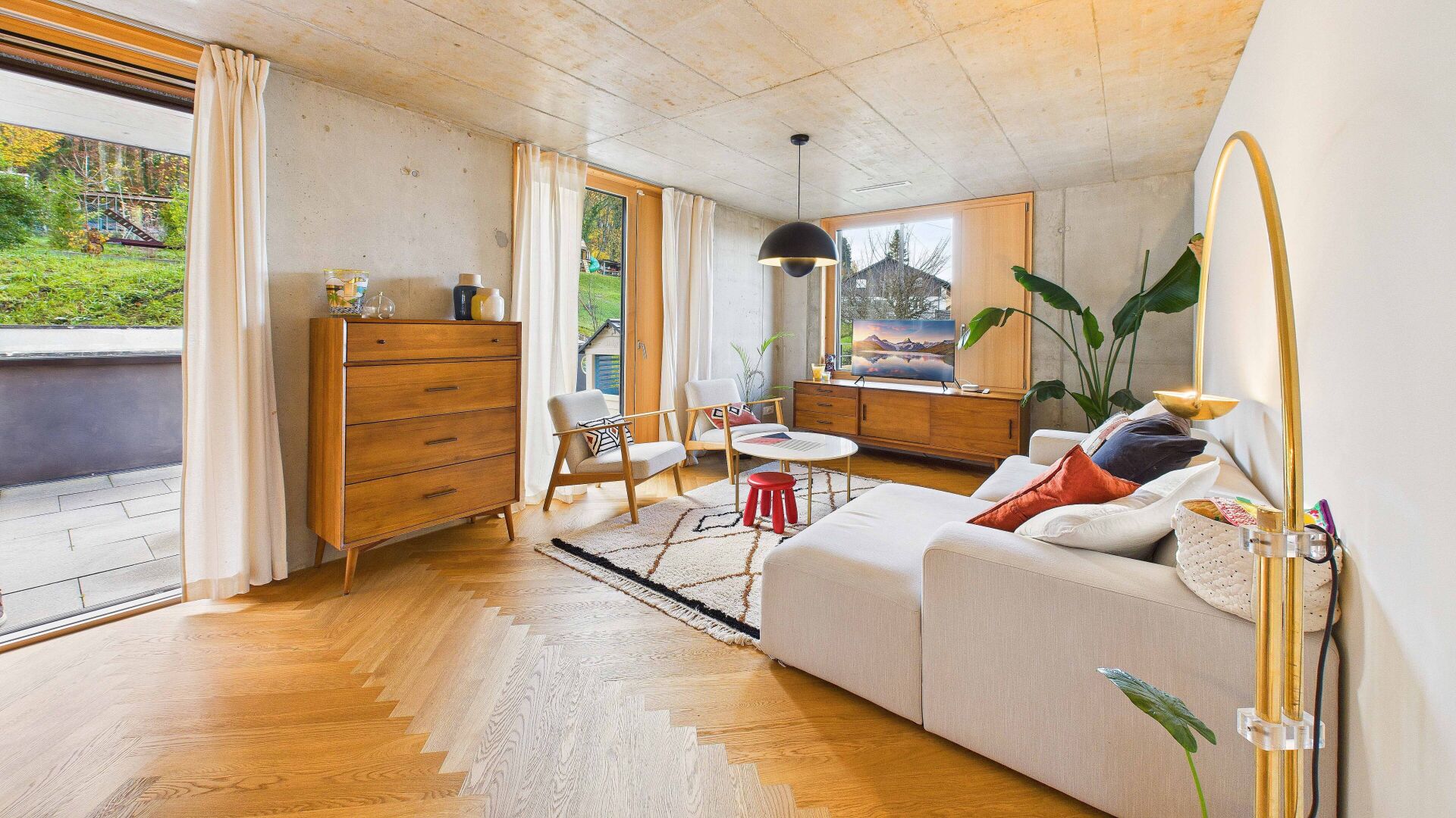 Modernes Wohnzimmer mit Betonwänden und Holzdetails