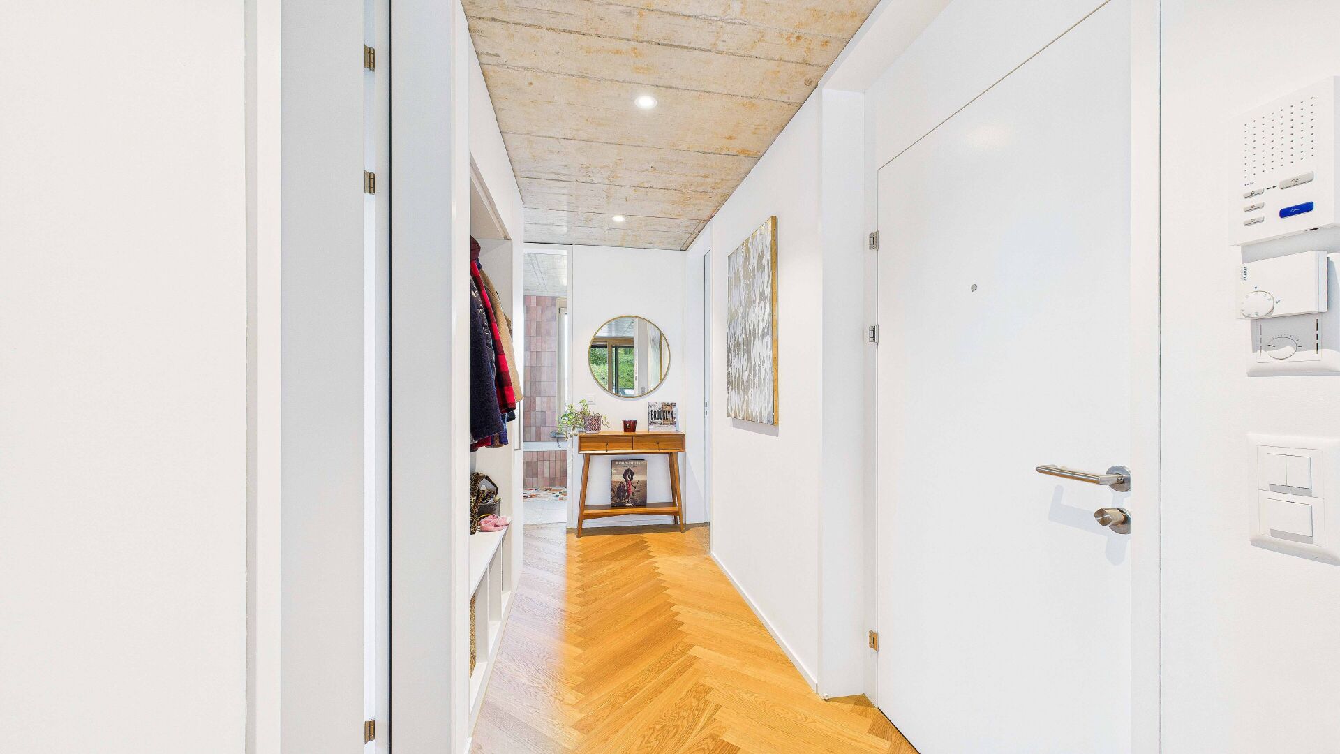 Heller Flur mit Holzboden und weißem Interieur