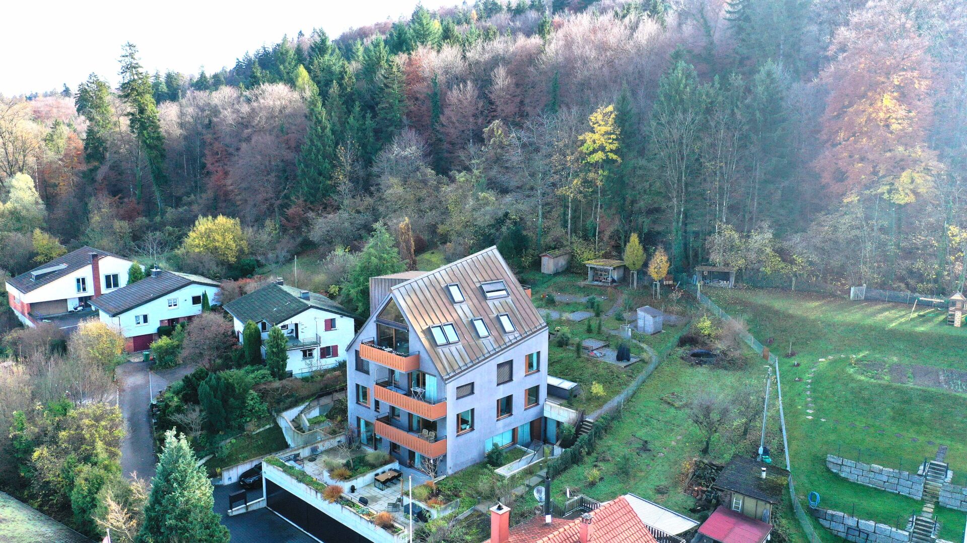 Luftaufnahme eines Wohnhauses in grüner Hanglage