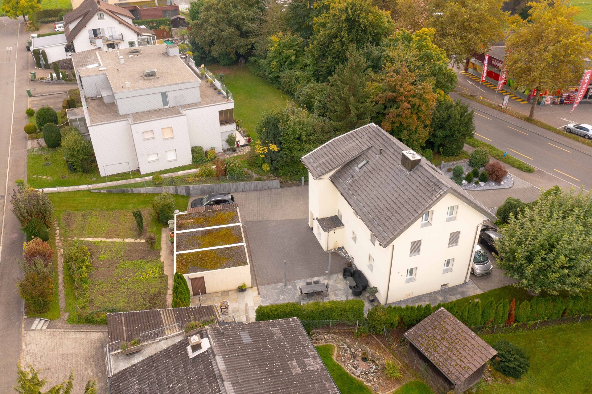 Luftaufnahme eines Wohngrundstücks mit mehreren Häusern und Gartenflächen
