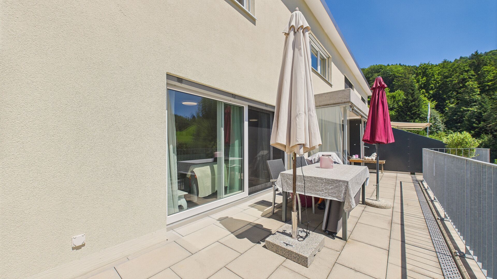 Terrasse mit Glasfront und Sonnenschirmen