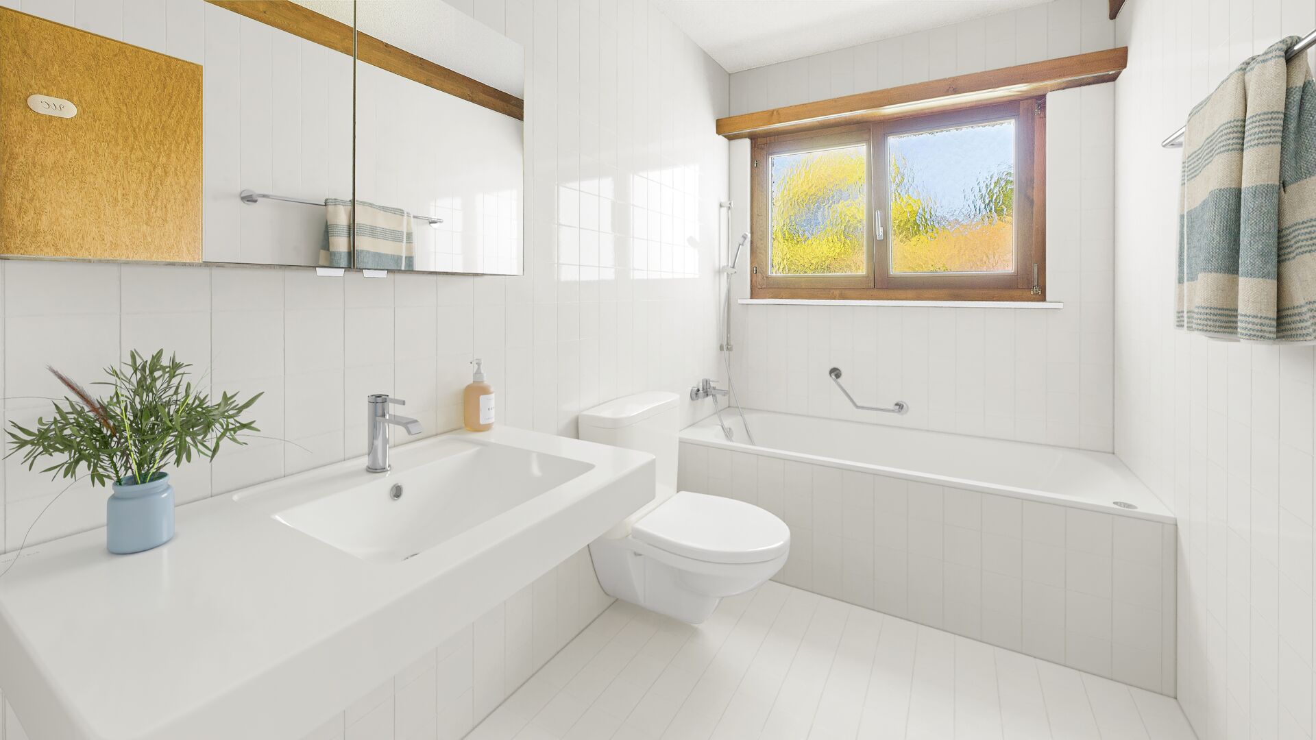 Helles Badezimmer mit Badewanne und Fenster