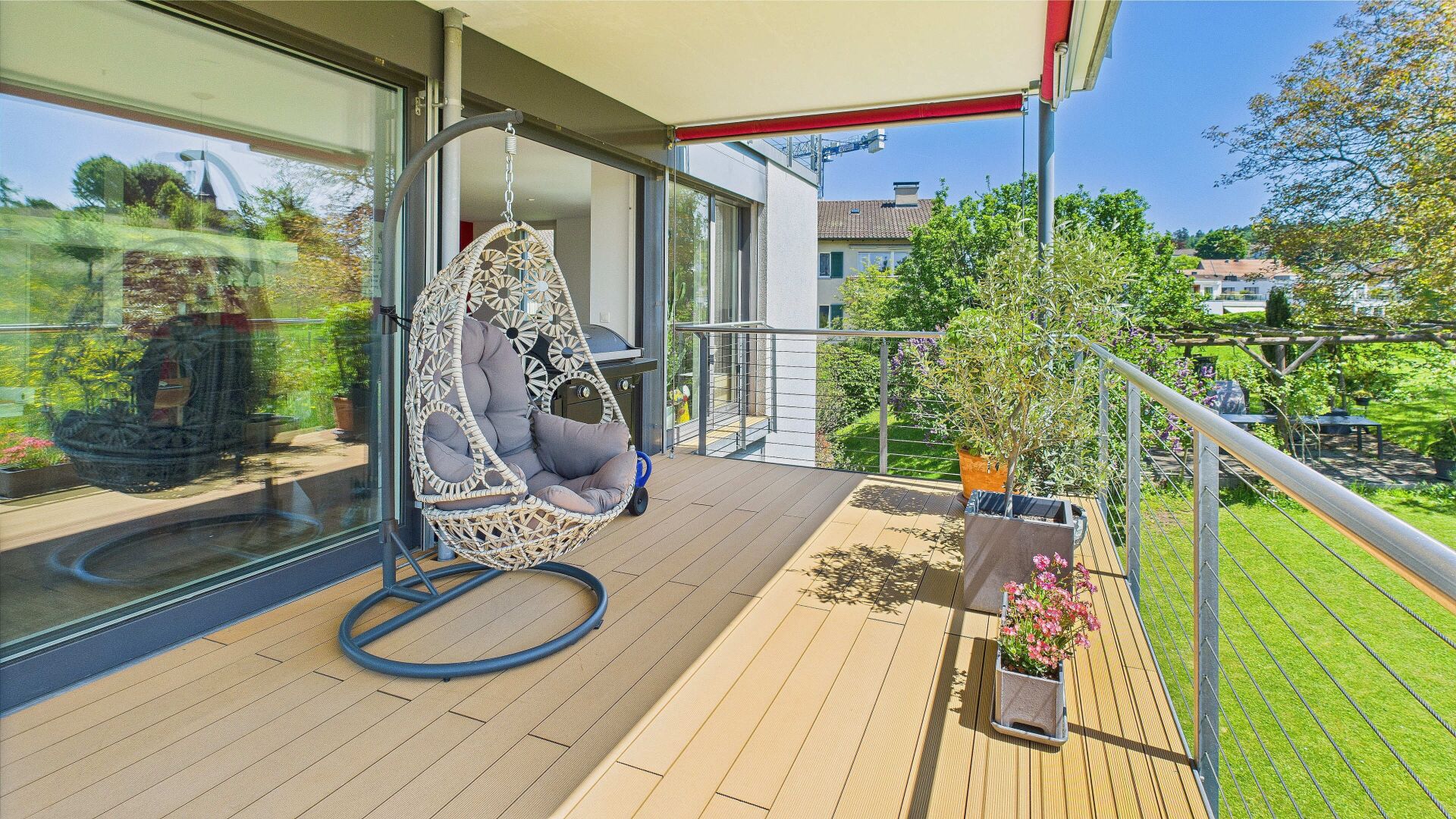 Balkon mit Hängesessel und Gartenblick