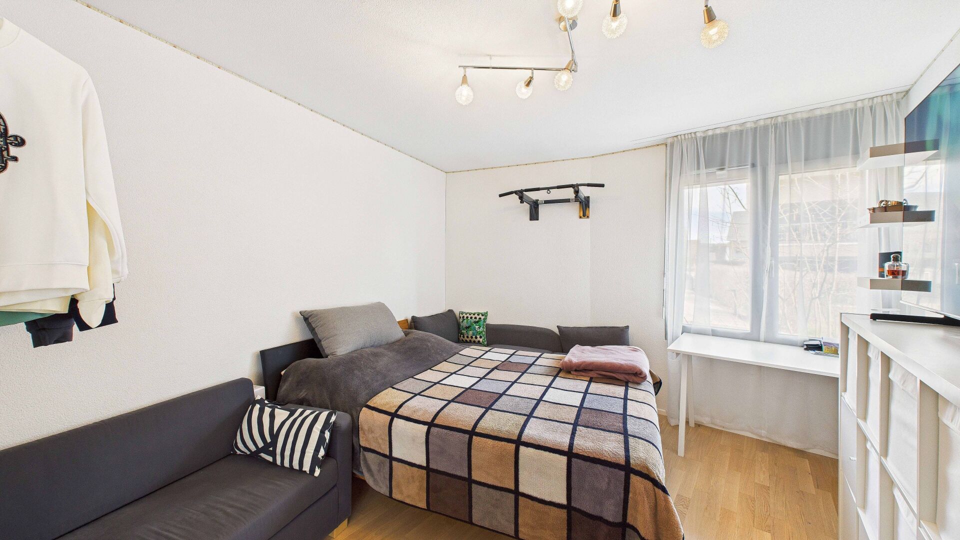 Helles Schlafzimmer mit Bett und Sofa
