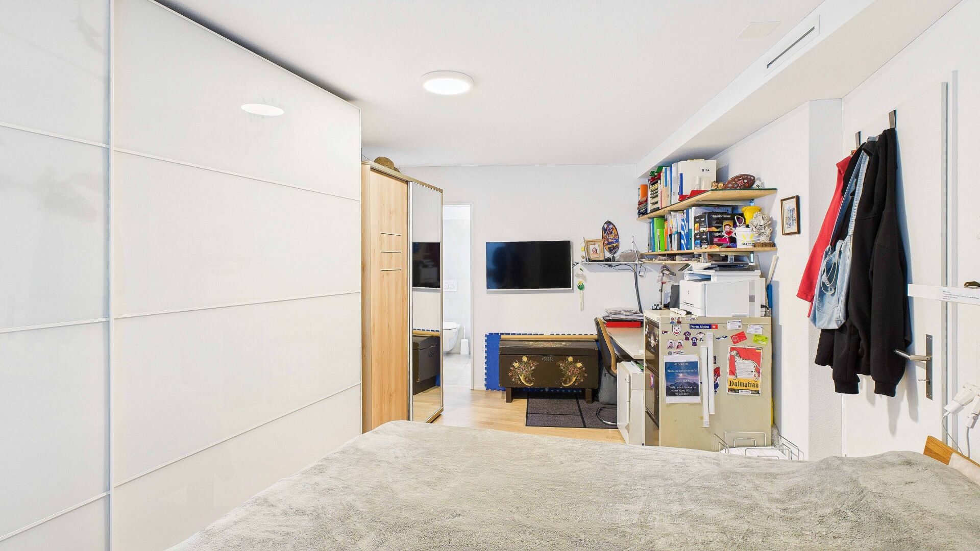 Helles, aufgeräumtes Schlafzimmer mit Arbeitsbereich