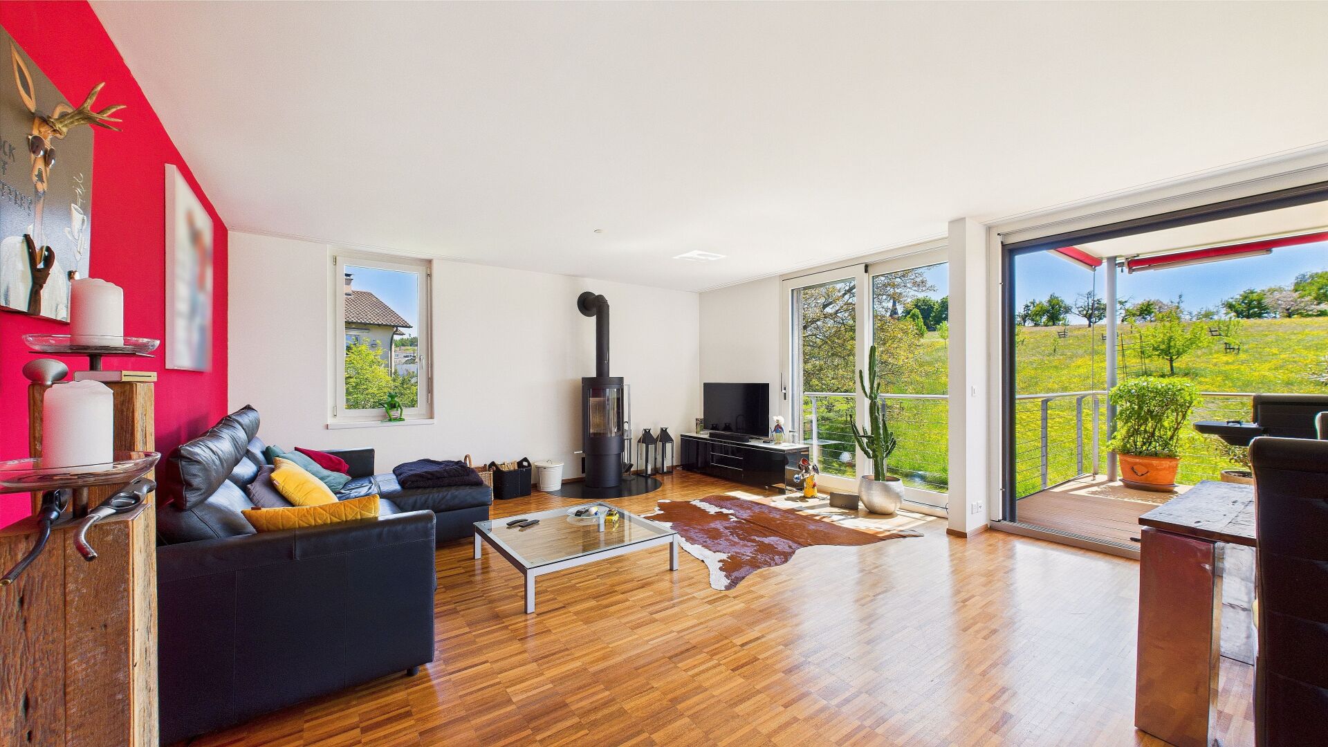 Helles Wohnzimmer mit Kamin und Balkonblick