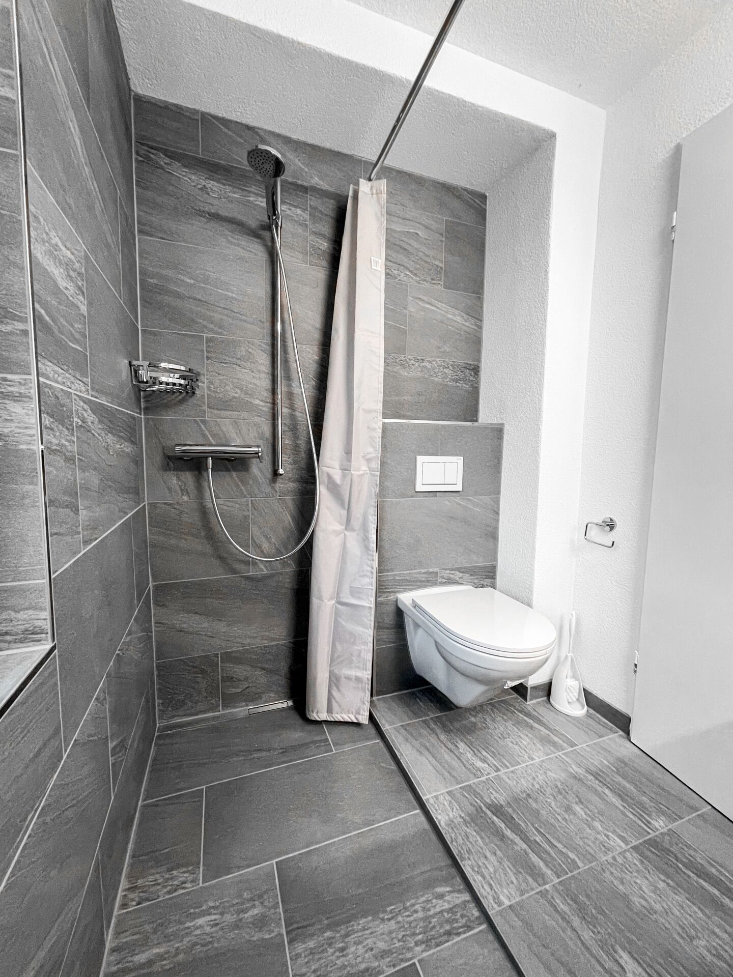 Modernes Bad mit Dusche und wandhängendem WC