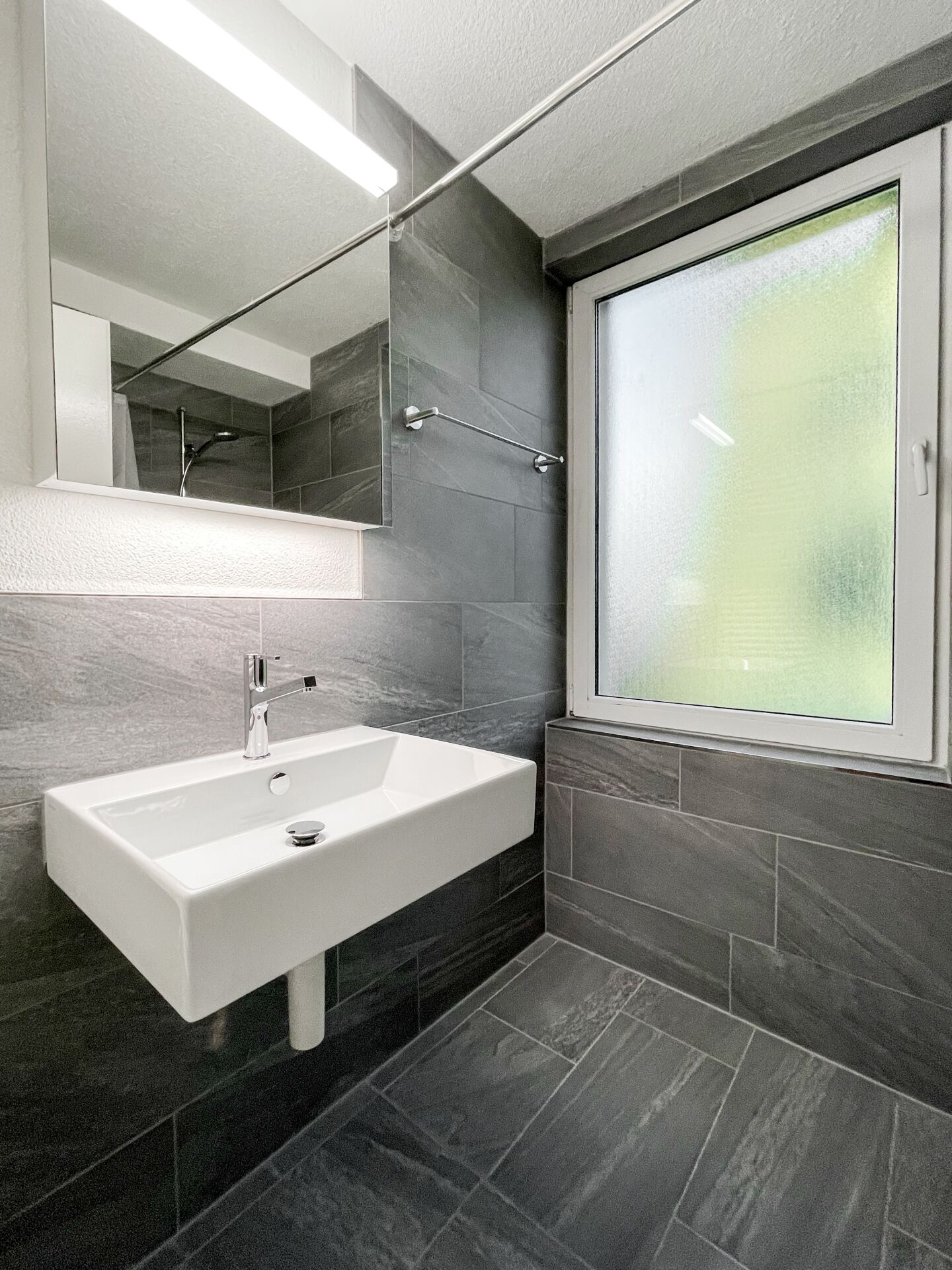 Modernes Badezimmer mit Waschbecken und Fenster