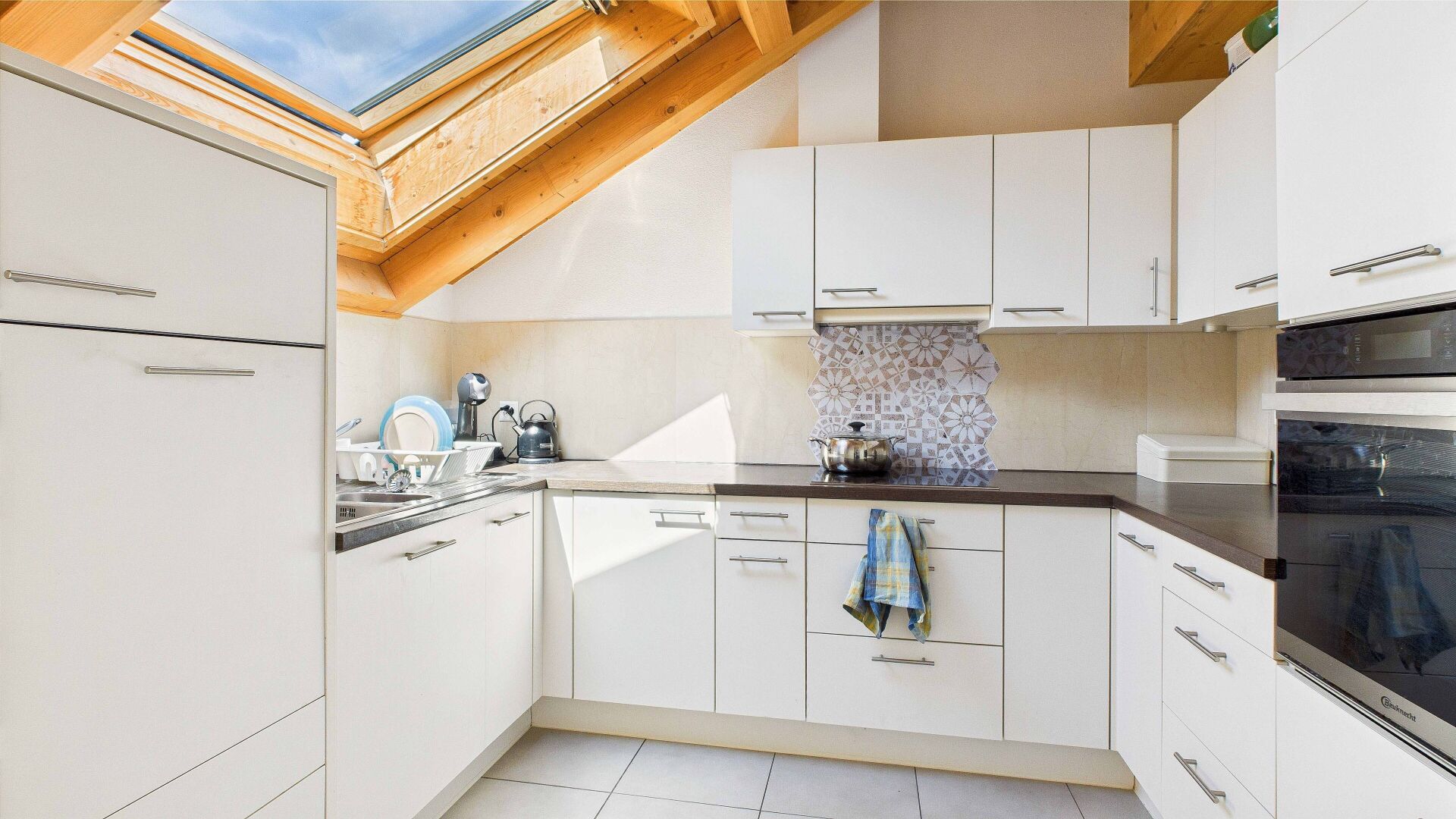Helle Dachgeschossküche mit Holzsparren