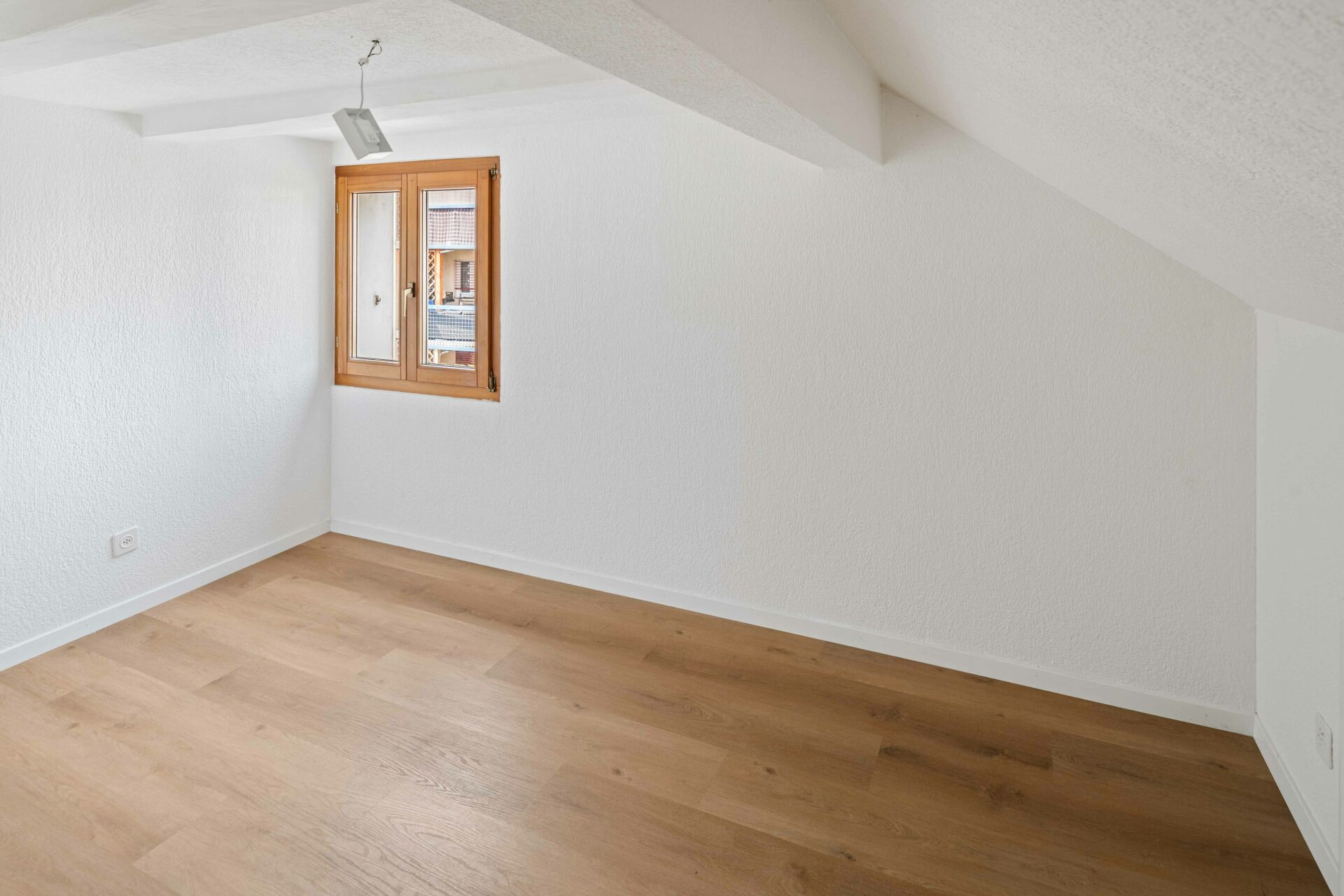 Helles Dachzimmer mit Holzfenster